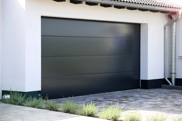 Portail double vantail en aluminium gris anthracite, à lames horizontales pleines, installé entre deux piliers en pierre de taille