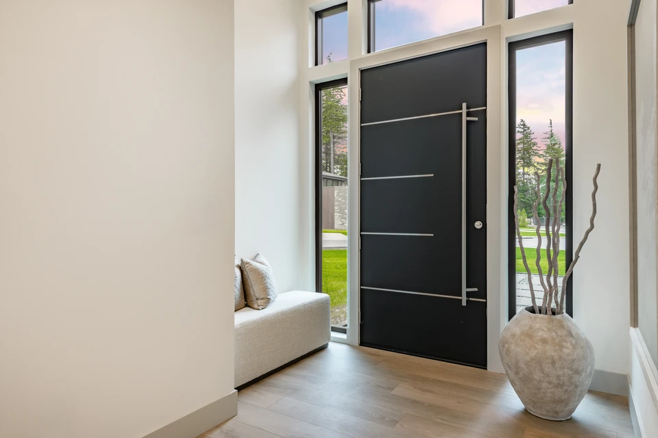 Porte d'entrée moderne en aluminium anthracite, design contemporain avec décor circulaire en inox brossé et vitrage ovale sablé translucide